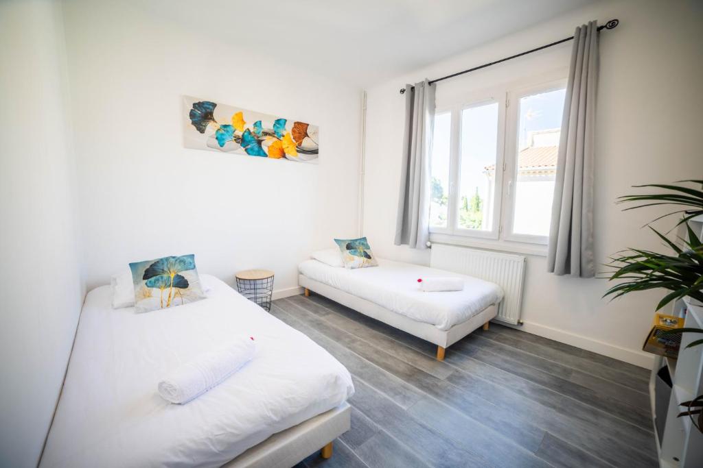 salon z 2 łóżkami i kanapą w obiekcie VILLA COSYFAMILY PISCINE WIFI 15MIN PLAGE idéal FAMILLE - TopProsConciergerie w mieście Pérols