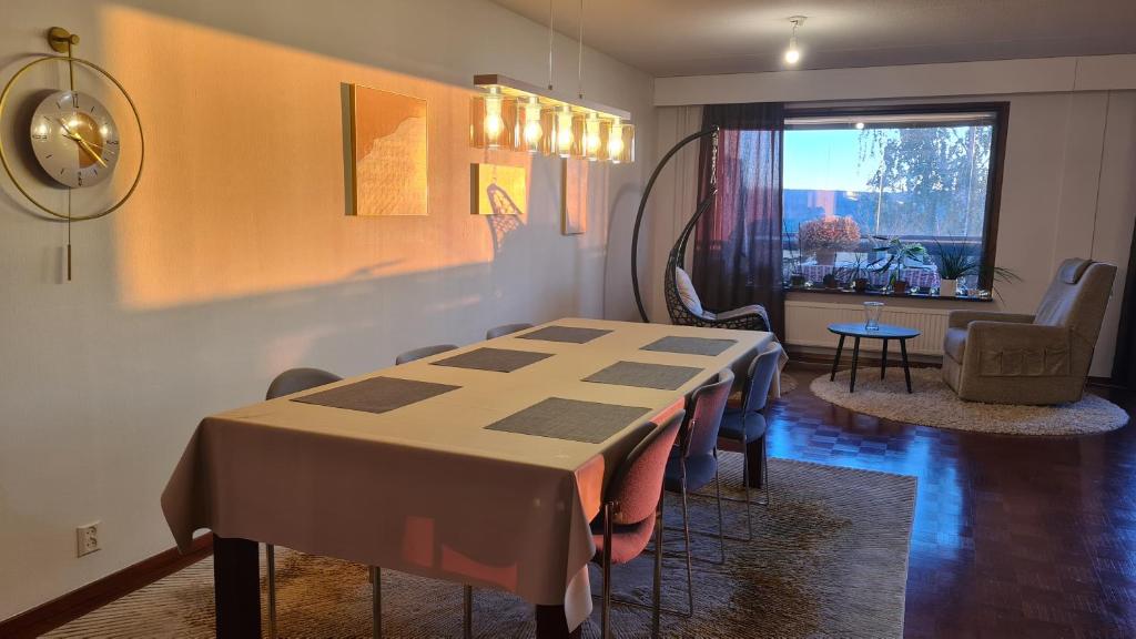 a dining room with a table and a living room at 3-bedroom lake view and near center apartment with sauna in Lahti