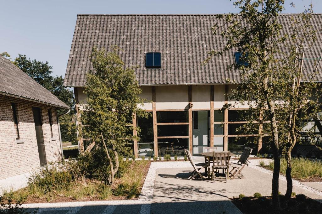 ein Haus mit einem Tisch und Stühlen davor in der Unterkunft Entre Nous in Herk-de-Stad