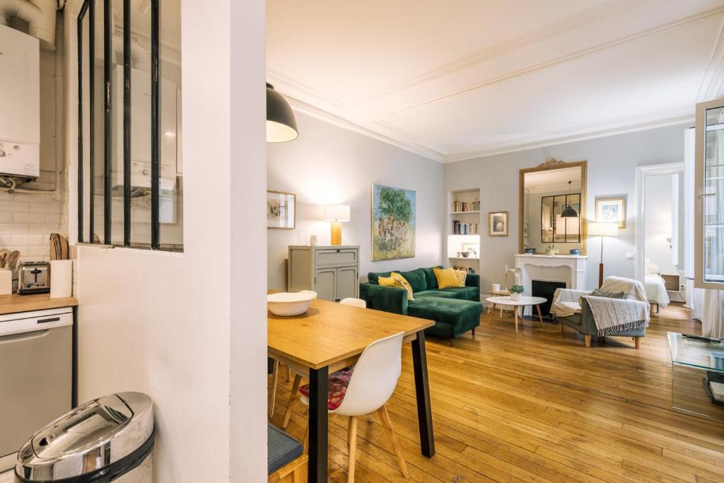 une cuisine et un salon avec une table et un canapé dans l'établissement GuestReady - Apt spacieux et exquis dans le 17ème, à Paris