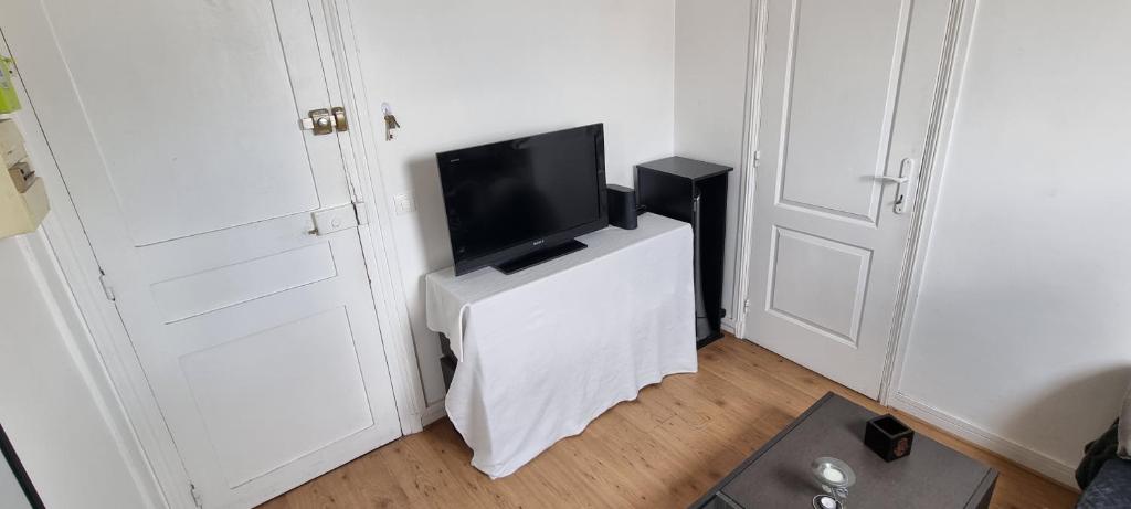 - une télévision assise sur un support blanc dans l'établissement Le Petit Paris, à Paris