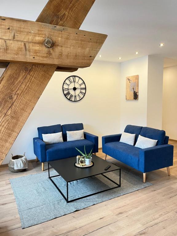 un salon avec deux canapés bleus et une table dans l'établissement Appartement hyper centre lit King Seize, à Épinal