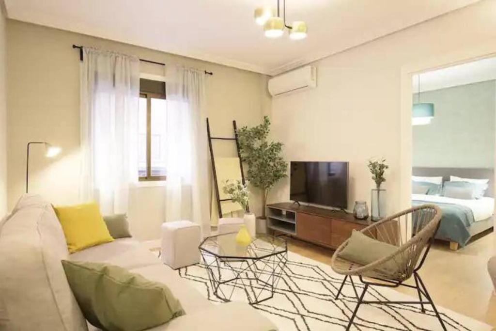 een woonkamer met een bank, een tv en een bed bij GuestReady - Un Moderno Apartamento a un Paso de la Plaza Mayor in Madrid