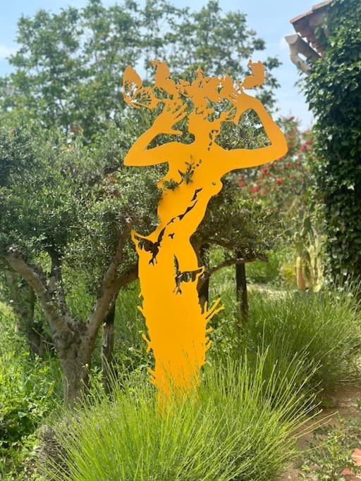 un panneau jaune dans l'herbe à côté d'un arbre dans l'établissement la maison de l'artiste, à Tourrettes-sur-Loup