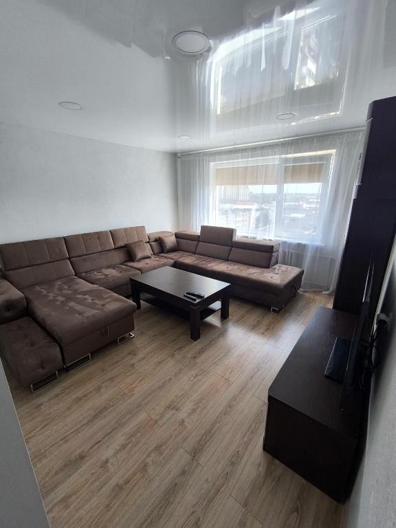 a living room with a couch and a coffee table at Sky View in Marijampolė