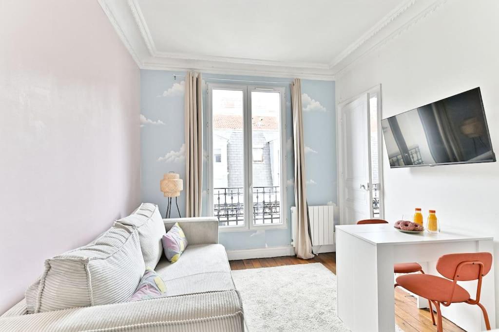 un salon avec un canapé blanc et une table dans l'établissement Appartement charmant et coloré Montparnasse, à Paris