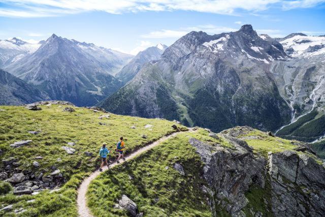 two people walking on a trail on a mountain at Self-Service Guesthouse Berggeist in Saas-Fee
