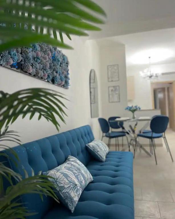 a blue couch in a living room with a table at Casa delle Belle Donne in Pisa