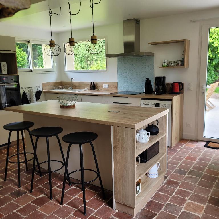 une cuisine avec un grand îlot en bois et des tabourets de bar dans l'établissement Maison 1810 - Slow tourism, à Fosseux