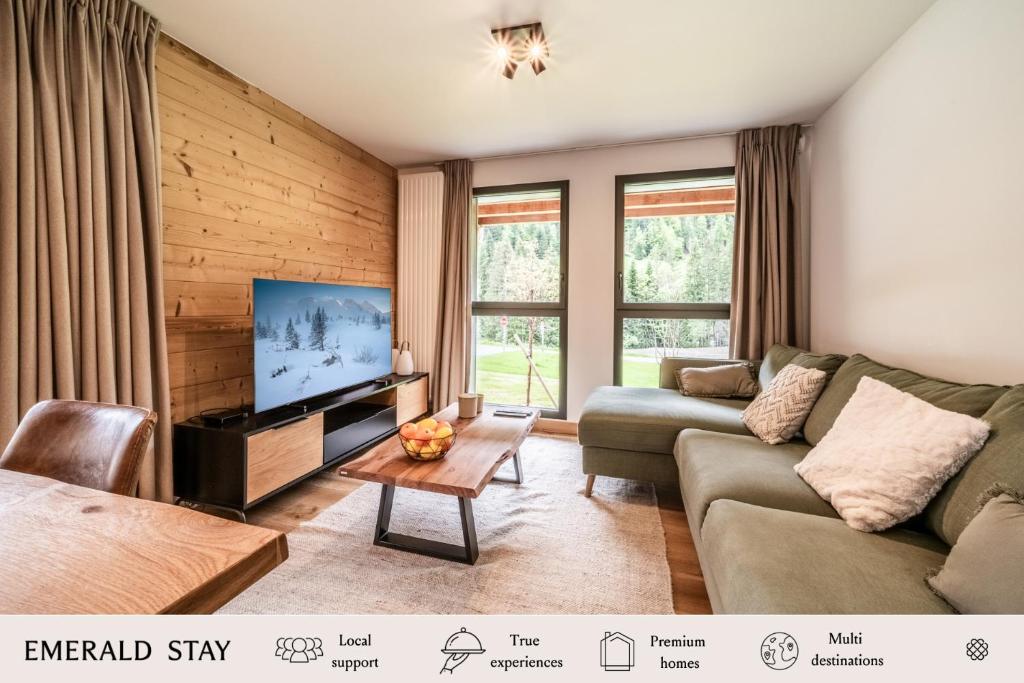 un salon avec un canapé et une télévision dans l'établissement Apartment Primerose Les Gets - by EMERALD STAY, aux Gets