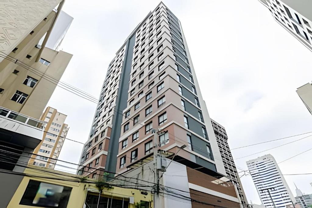 a tall building in the middle of a city at Easy Emiliano - Apartamentos UROOMS in Curitiba