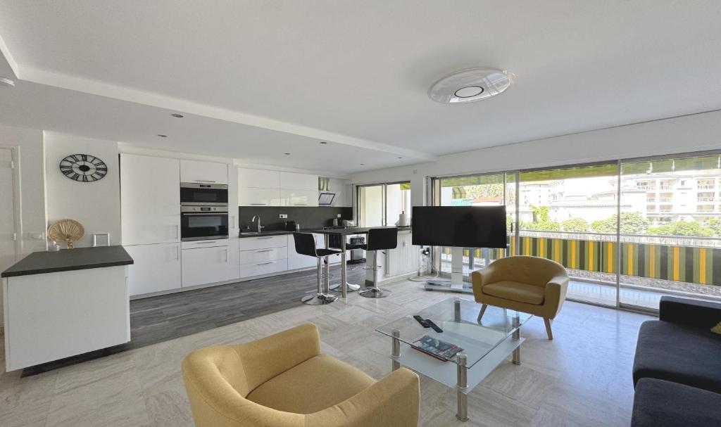 Il comprend un salon doté d'un canapé et d'une télévision. dans l'établissement Charming 2 room , 52 m2, very spacious, bright and near sea Martinez hotel, à Cannes