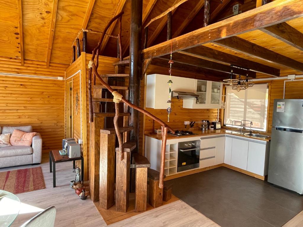 a kitchen with a spiral staircase in a cabin at Cabaña Palafito in Coelemu