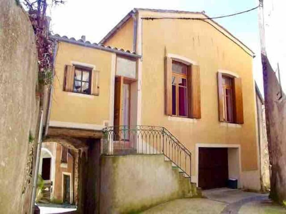 une grande maison avec un escalier en face de celle-ci dans l'établissement Gîte de la Placette, à Aumessas