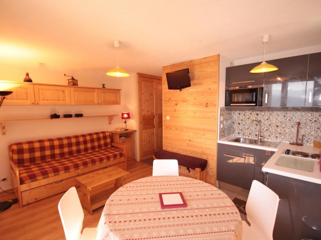 eine Küche mit einem Tisch und einer Couch in einem Zimmer in der Unterkunft Charmant appart au 2e étage, 5 pers, balcon, WiFi, casier à skis, Les Saisies - FR-1-293-287 in Hauteluce