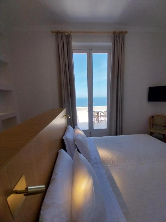 a bedroom with a bed with a view of the ocean at Hotel Dania in Sorrento