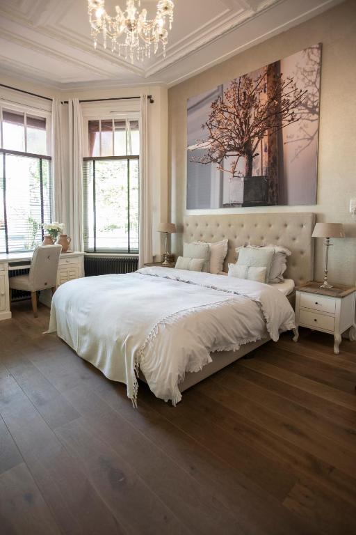 een slaapkamer met een groot bed en een kroonluchter bij Zenzez Hotel & Lounge in Apeldoorn