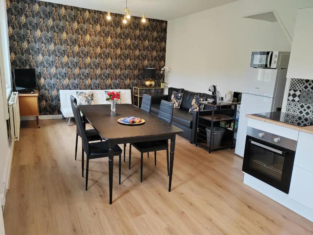 une salle à manger et un salon avec une table et des chaises dans l'établissement L'Art Nouveau près de Nancy, à Varangéville