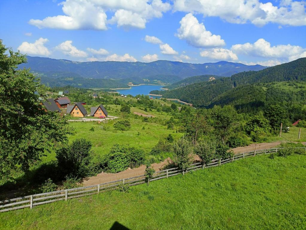 a view of a field with a fence and a lake at Aurora Tara 2 in Jezdići