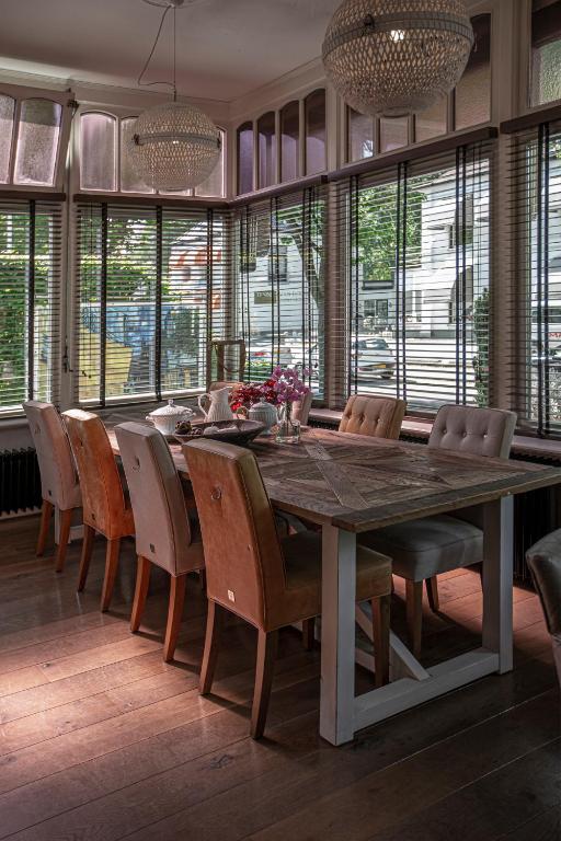 een eetkamer met een grote houten tafel en stoelen bij Zenzez Hotel & Lounge in Apeldoorn