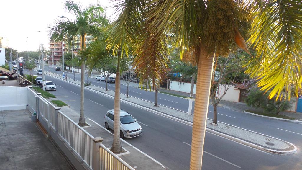 vistas a una calle con palmeras y coches en Praia do Forte Cabo Frio Apartment, en Cabo Frío