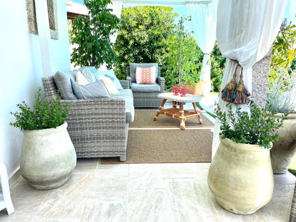 une terrasse avec des canapés et une table avec des plantes dans l'établissement Villa Adel, à San Teodoro