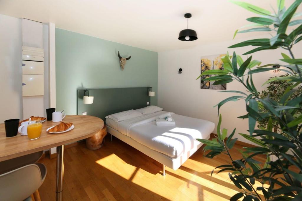 - une chambre avec un lit et une table avec une assiette de nourriture dans l'établissement 202 - Studio calme et reposant a Paris 5 - FLAT-GUEST, à Paris