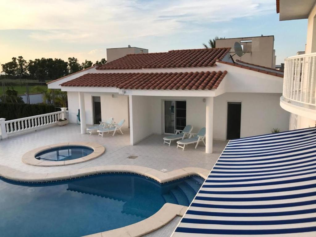 a villa with a swimming pool and a house at Residencial San Francisco in L'Eucaliptus