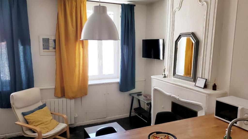 un salon avec une cheminée et une fenêtre dans l'établissement La Couronne - 2 chambres près du marché, à La Rochelle