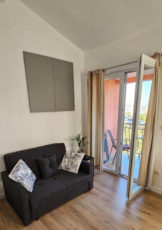a living room with a couch and a sliding glass door at Apartment Grubelić in Tribunj