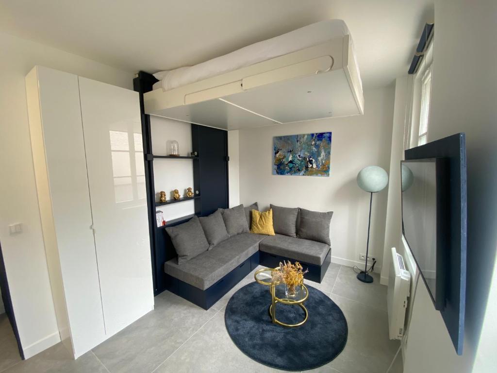 un salon avec un canapé et une table dans l'établissement Studio confortable, à Pantin