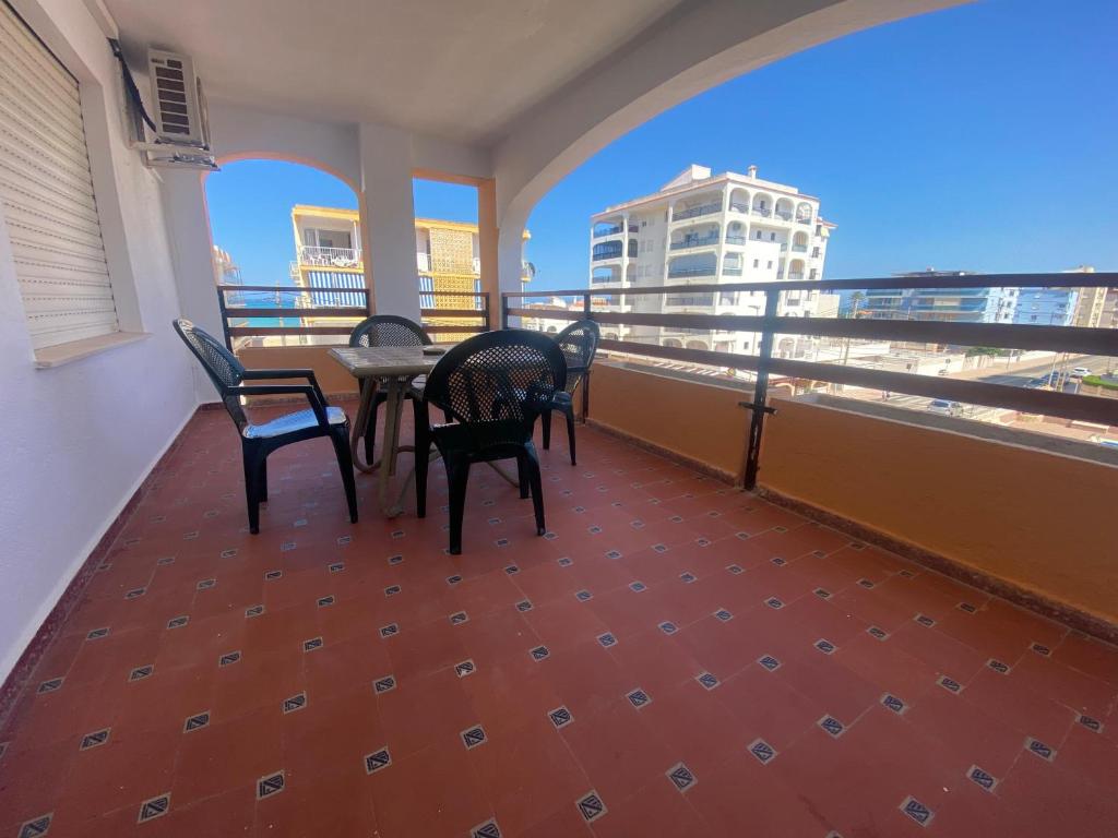 Un balcón con sillas y una mesa en un edificio. en Maripatri Solo Familias Serviplaya!!!, en Casas Las Basas
