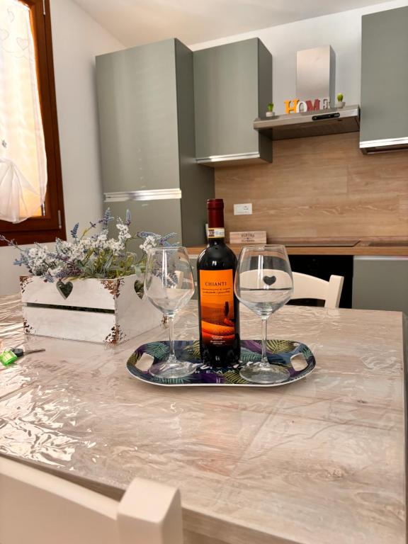 een fles wijn en twee wijnglazen op een aanrecht bij TuscanyAnnerelax in Cecina