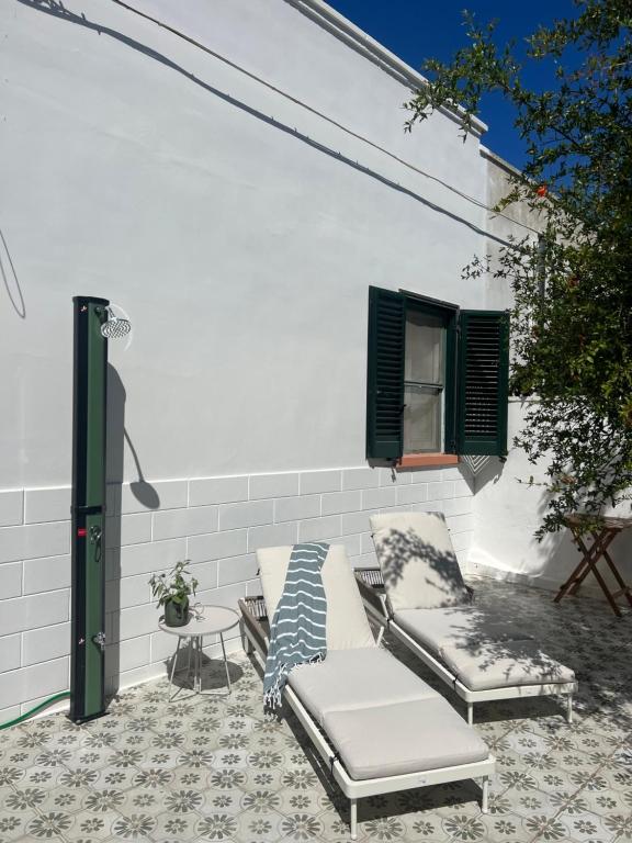 a patio with two chairs and a table and a window at Casa Sasa in Porto Cesareo
