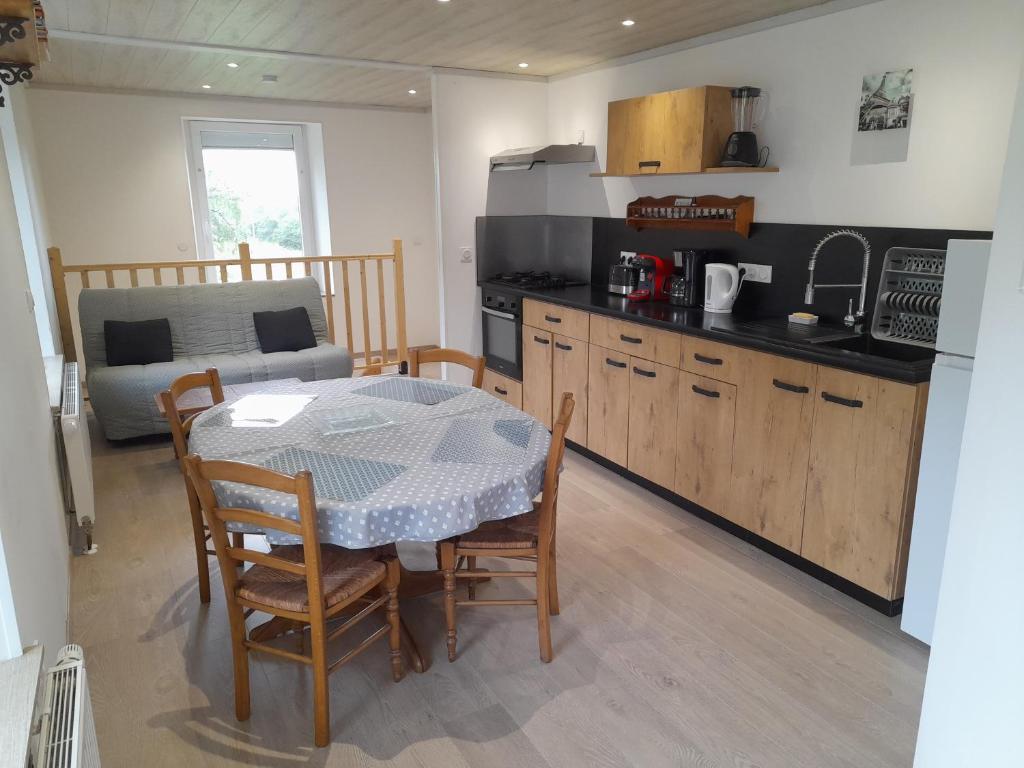 une cuisine et une salle à manger avec une table et des chaises dans l'établissement Le Blanzey, à Fougerolles
