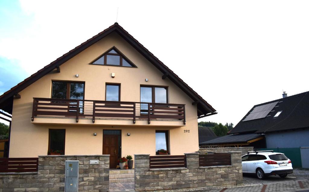 a house with a balcony on top of it at Ubytovanie Home Katka in Bešeňová