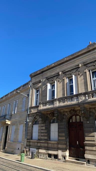 un vieux bâtiment avec une porte en bois dans une rue dans l'établissement Splendide Haussmannien dans hôtel particulier, à Bordeaux