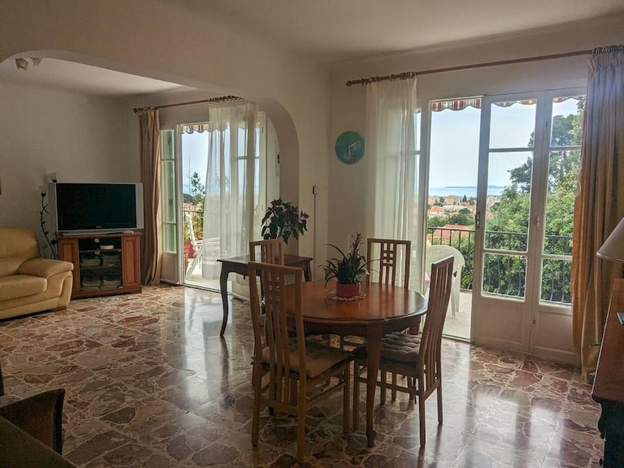 un salon avec une table, des chaises et une télévision dans l'établissement Oasis de sérénité avec vue mer imprenable, à Cagnes-sur-Mer