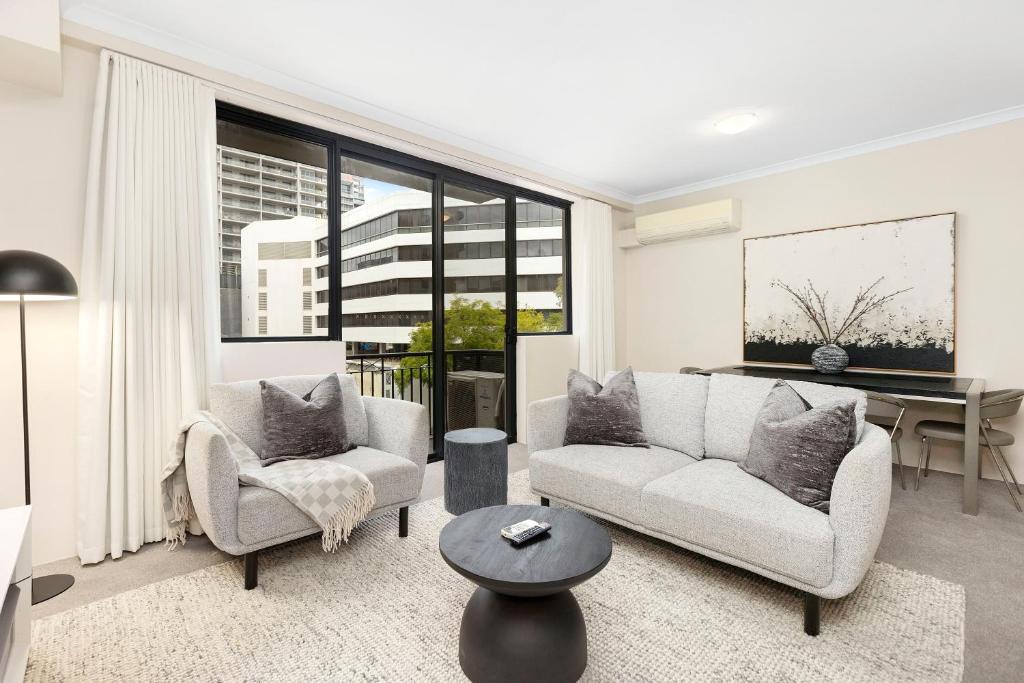 a living room with two couches and a table at 1BR Stylish Suite on Hay St in Perth