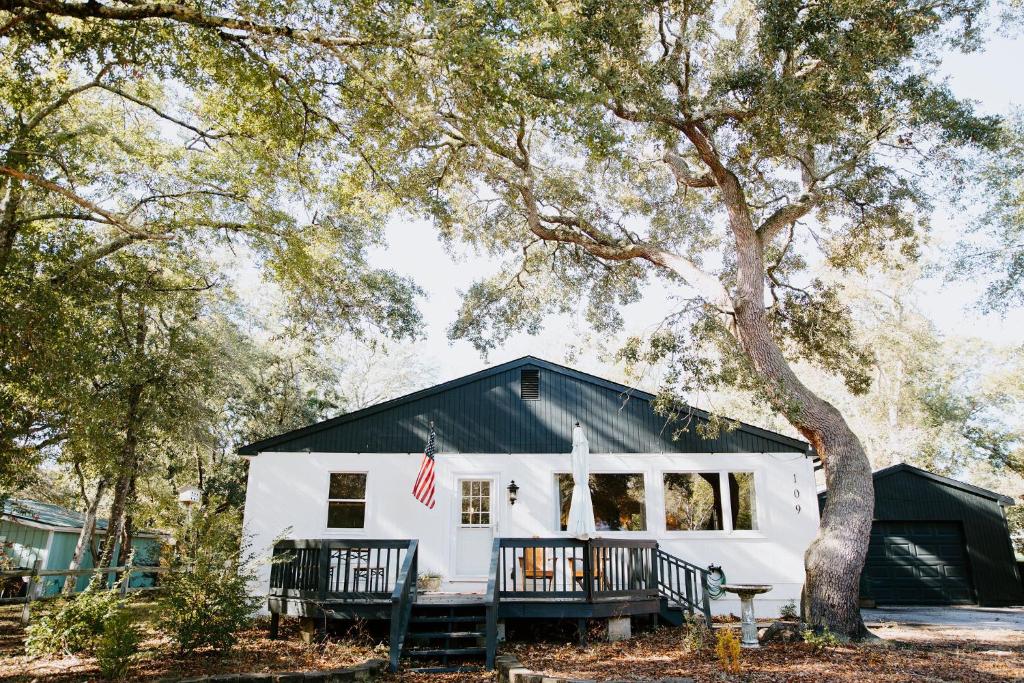 una casa blanca con techo negro en Cottage by the Sea: Pagnotto Shellback House, en Oak Island