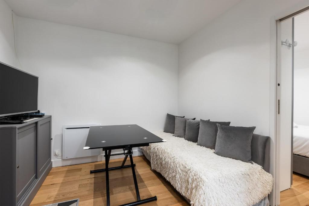 un salon avec un canapé et une table dans l'établissement Appartement Térreo - Welkeys, à Paris