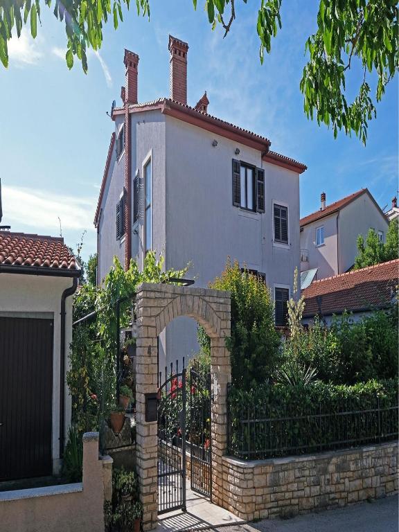 a house with an archway in front of a fence at Penthouse Stella in Pula