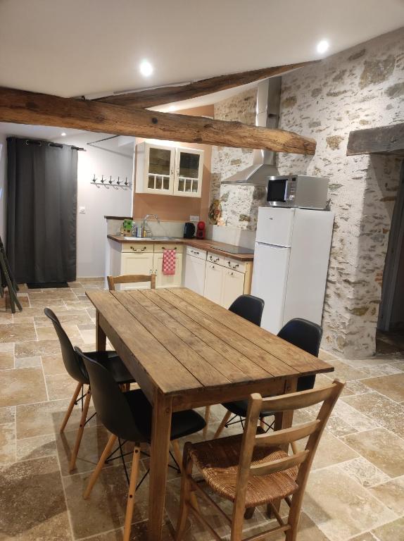 une cuisine avec une table et des chaises en bois dans l'établissement Les Gîtes du Lac - L'Ecurie - Maison 2 chambres 60m2 - Proche Nantes avec Terrasse, à La Chevrolière