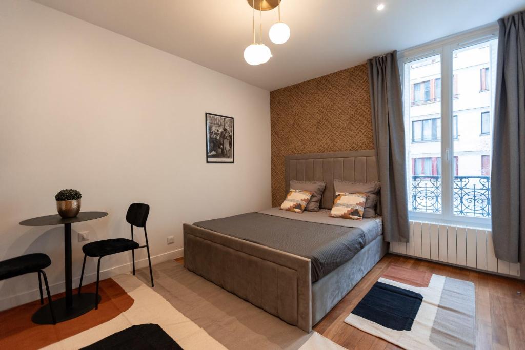 een slaapkamer met een bed en een raam bij Joli studio proche de paris -pantin in Pantin