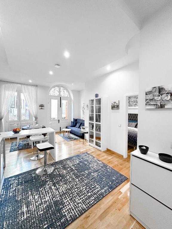 a white living room with a kitchen and a dining room at City Center Lodge in Pula