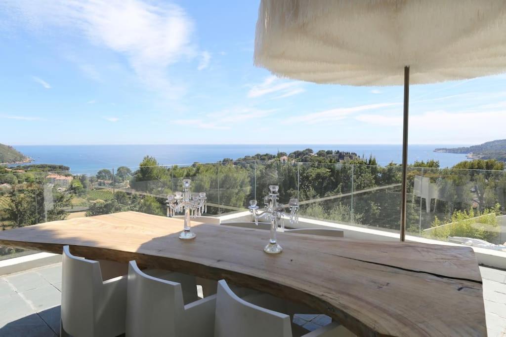 une table en bois sur un balcon avec vue sur l'océan dans l'établissement K-Sea Villa One - Villa Unique de Luxe à Cassis, à Cassis