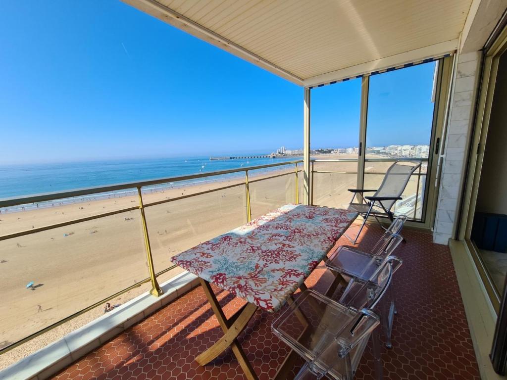 - un balcon avec une table et des chaises sur la plage dans l'établissement Le soleil appartement face mer, à Les Sables-dʼOlonne