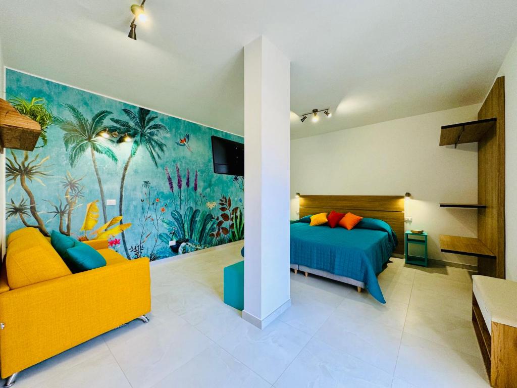 a bedroom with a blue bed and a yellow couch at YourHome - Blu Jade House in Piano di Sorrento