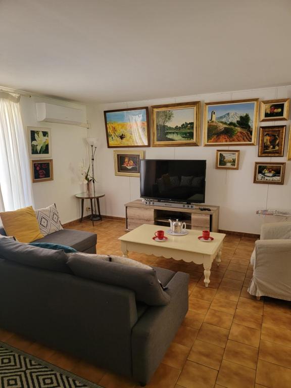 ランブクにあるMaison T4, campagne Provençale calme, tout confortのソファとテレビのあるリビングルーム