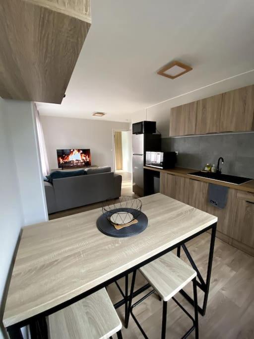 une cuisine avec une table et des chaises dans une pièce dans l'établissement Appartement 2-4 personnes - Triel Sur Seine, à Triel-sur-Seine